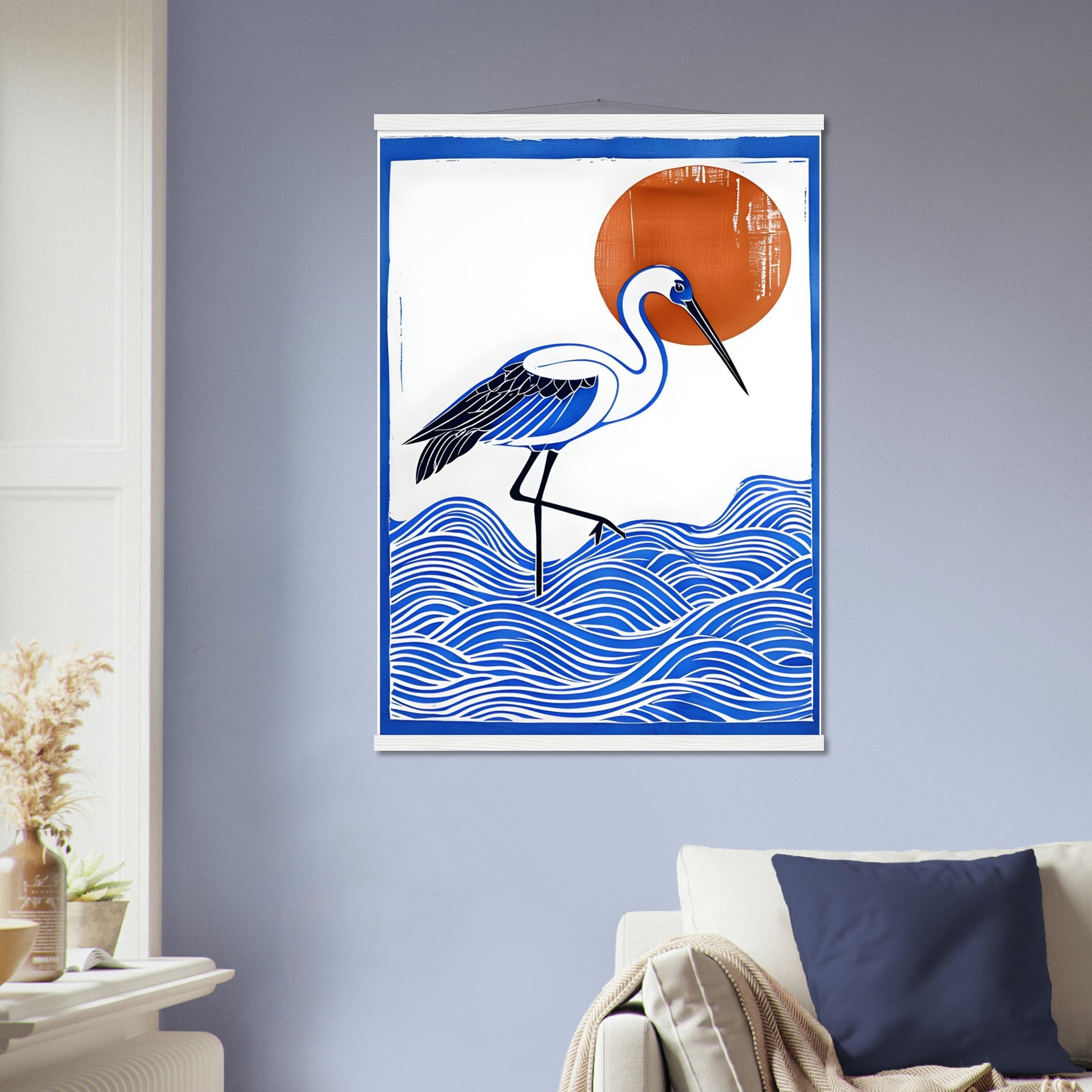 Decorative wall poster with a crane in the sea and sun design on a blue wall above a sofa.