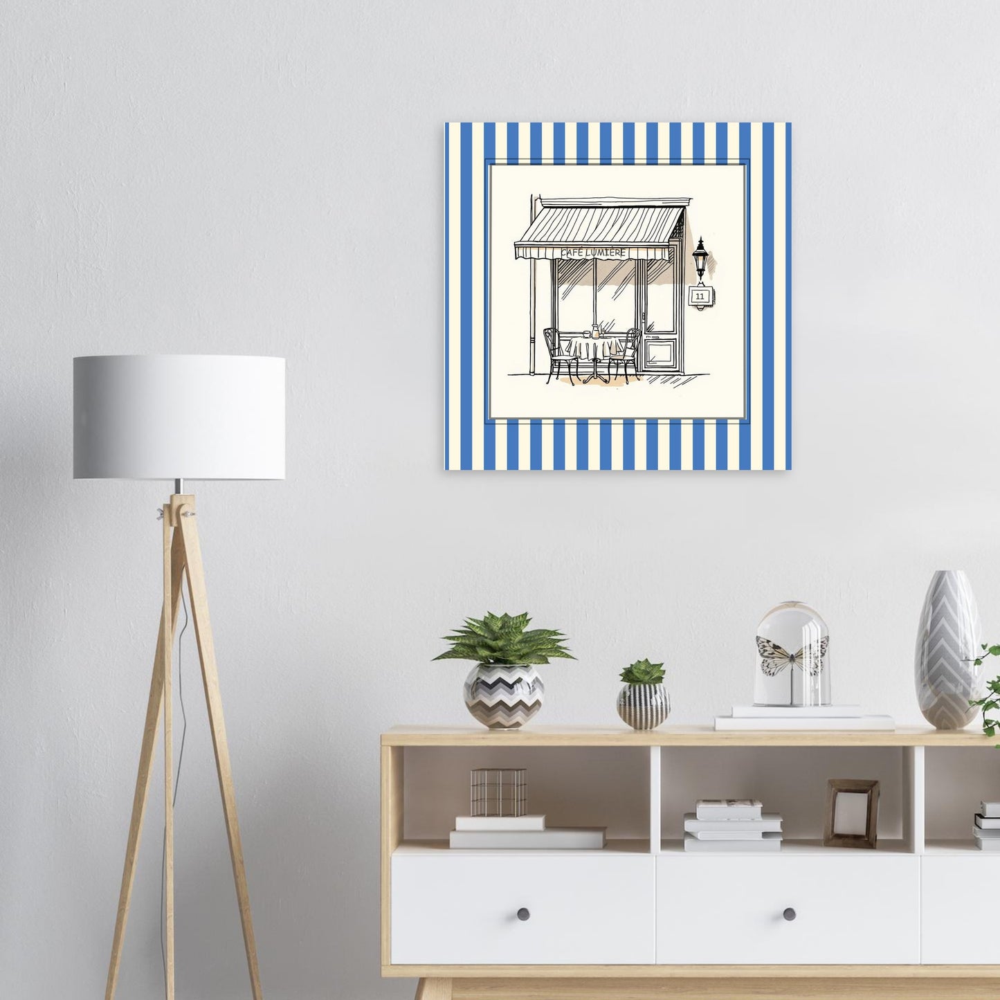 French café storefront art print in blue above a  modern white sideboard