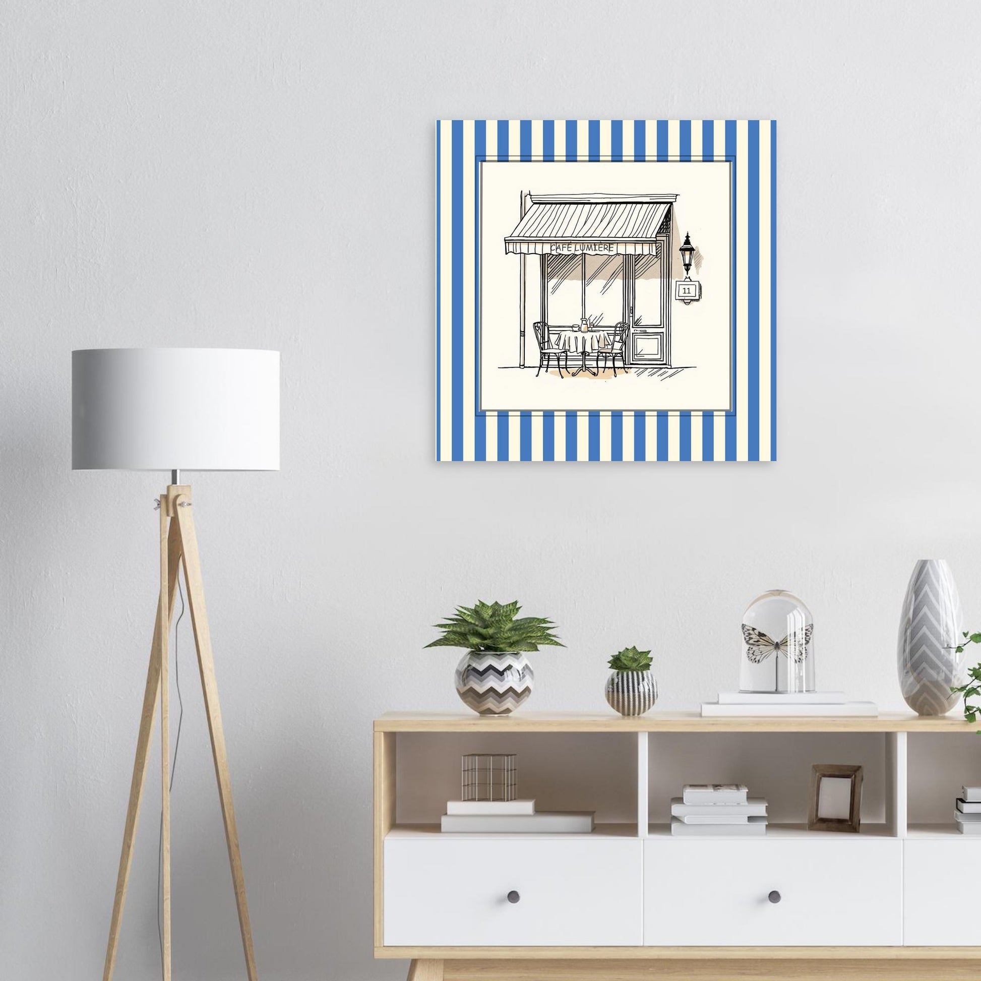 French café storefront art print in blue above a  modern white sideboard