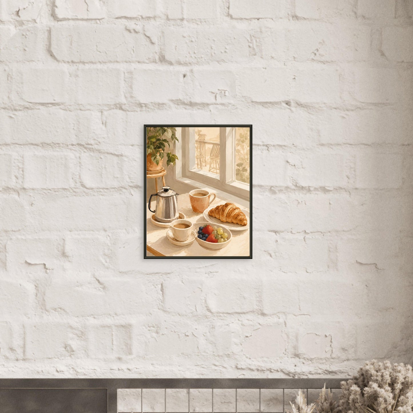 Framed photograph of a breakfast scene with a teapot, coffee cup, and croissant on a white brick wall.