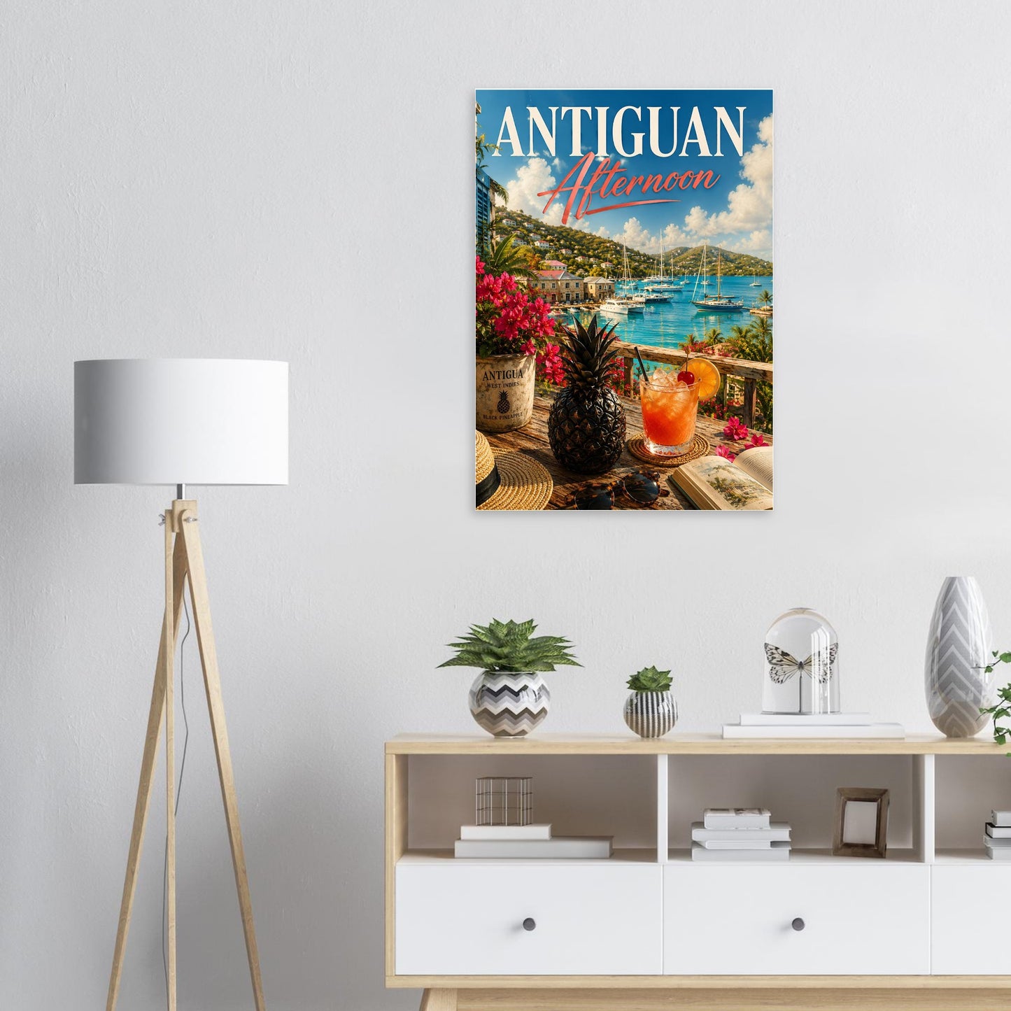 Poster of Antiguan Afternoon hanging on a wall above a white cabinet with decorative items.