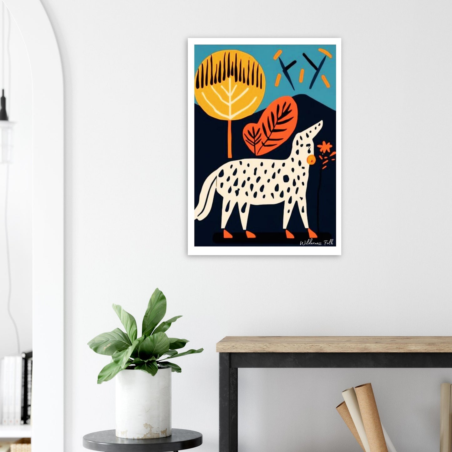 Framed artwork of a spotted animal with colorful leaves on a wall above a desk.