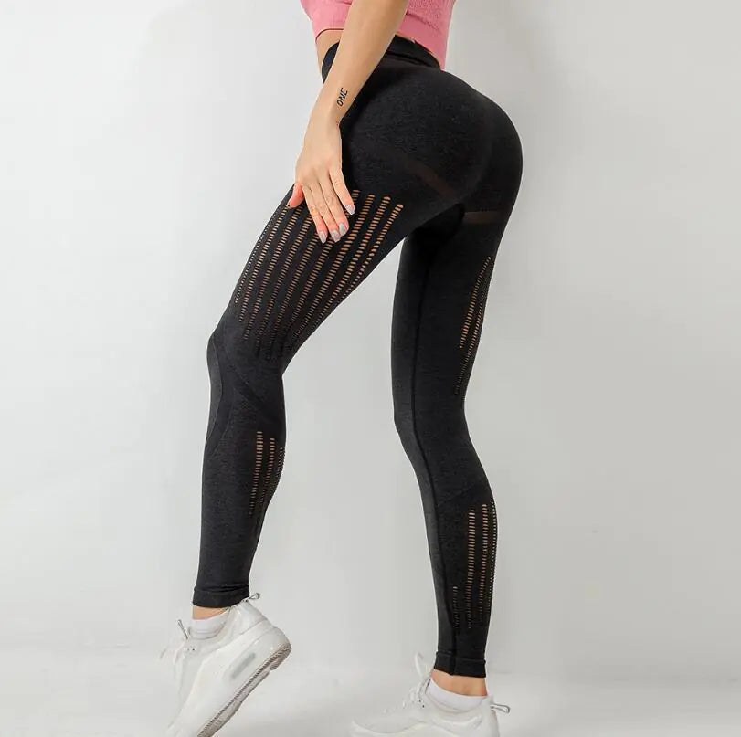 Black leggings with mesh panels worn by a person on a white background