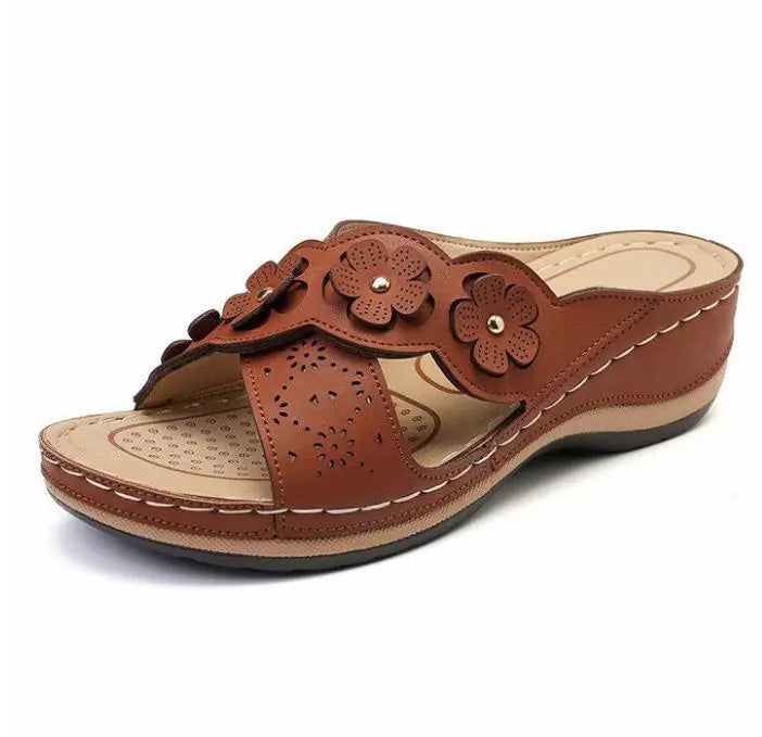Brown sandal with floral designs on a white background