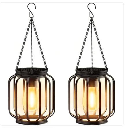 Two hanging lanterns with glass shades and metal frames on a white background