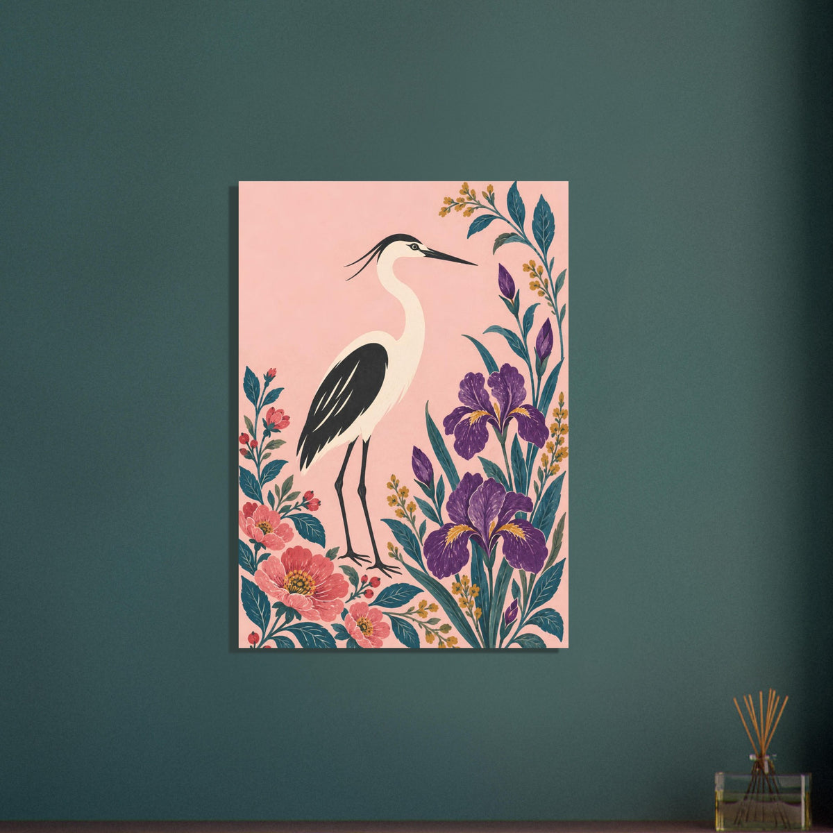 A vertical canvas wall art print featuring a heron and floral illustration, displayed on a dark teal wall next to a small glass reed diffuser.