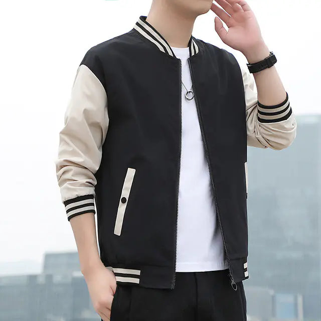 Person wearing a black and beige varsity jacket with a blurred background