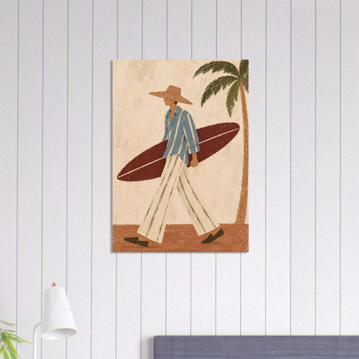 Unframed surfer print on a white panelled wall above a blue upholstered seat.