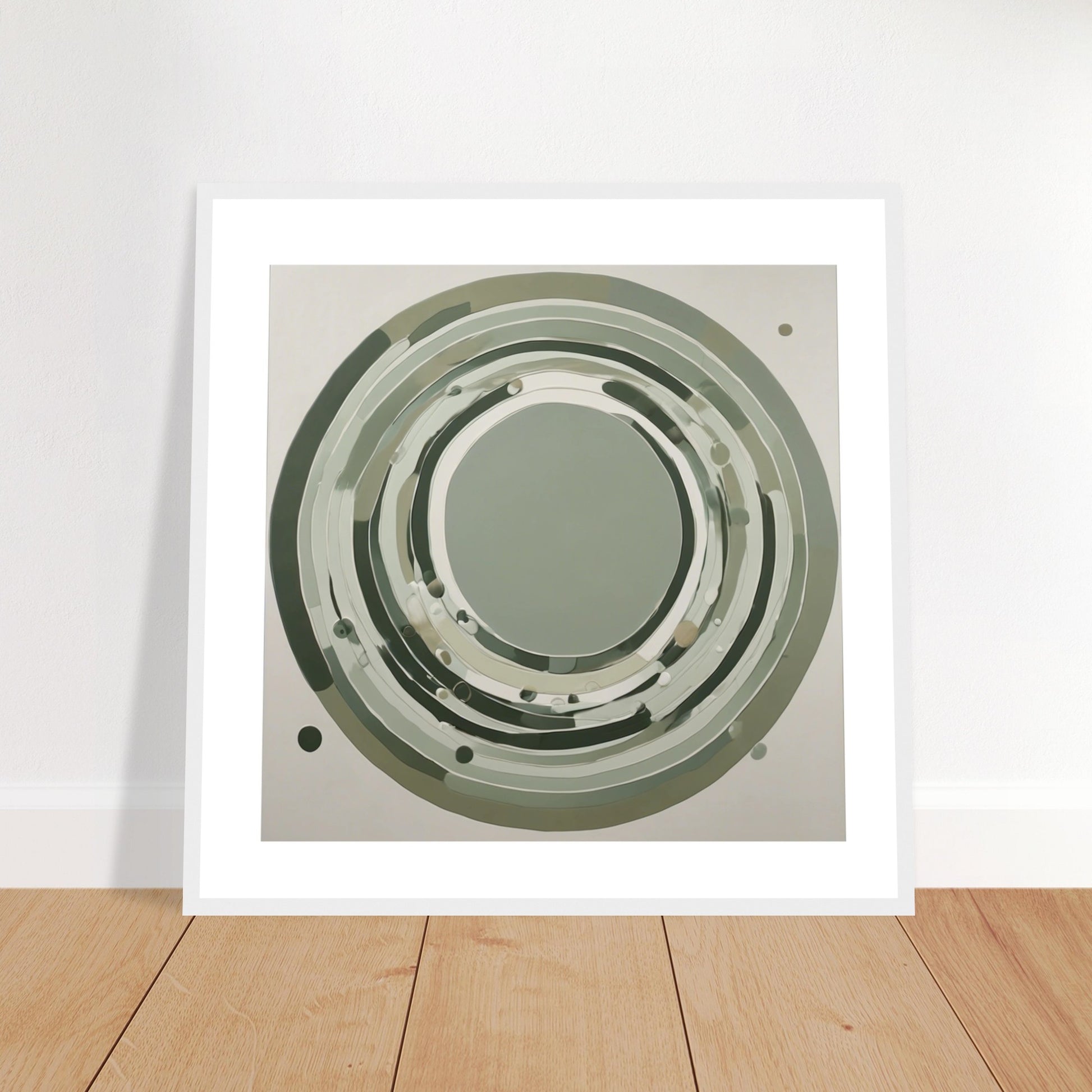 Framed sage green circular abstract poster leaning against a white wall on wooden flooring