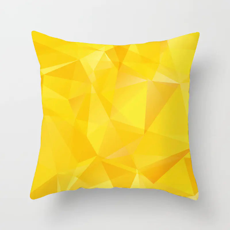Yellow geometric patterned pillow on a light gray background