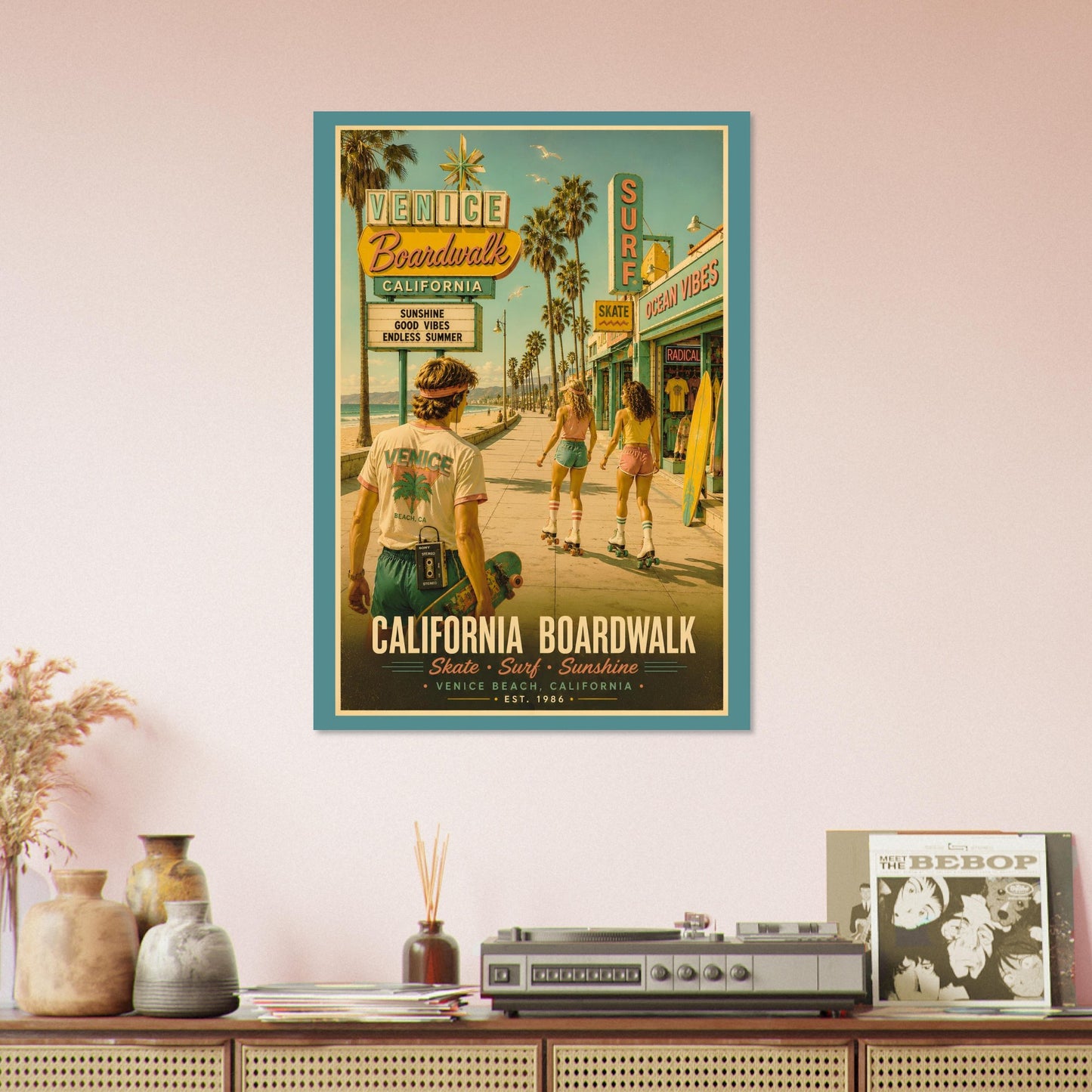 Framed poster of a vintage-style beach scene with people on a boardwalk, displayed on a wall above a wooden shelf.