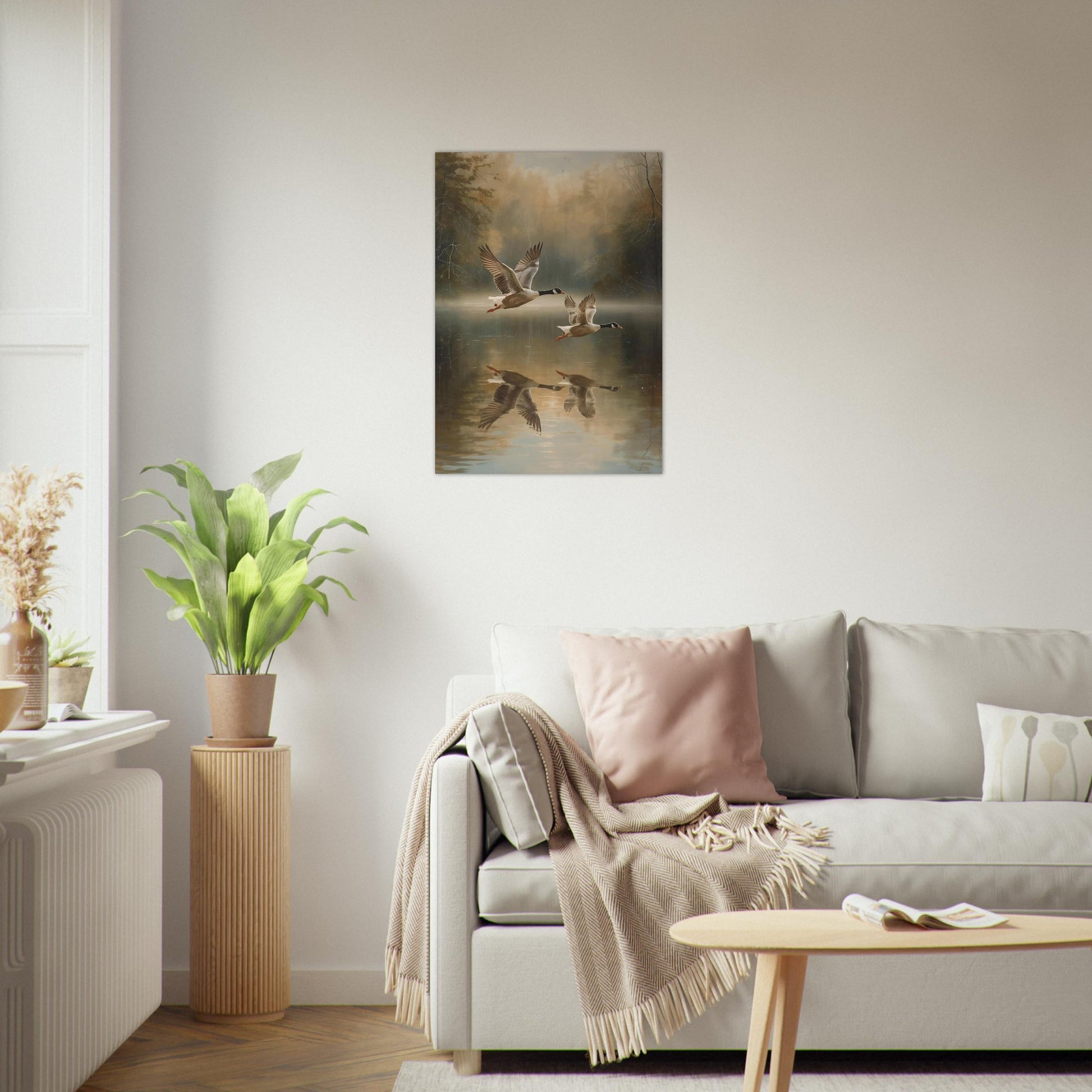 Living room with a painting of geese on a lake, a sofa with pillows, and a plant.