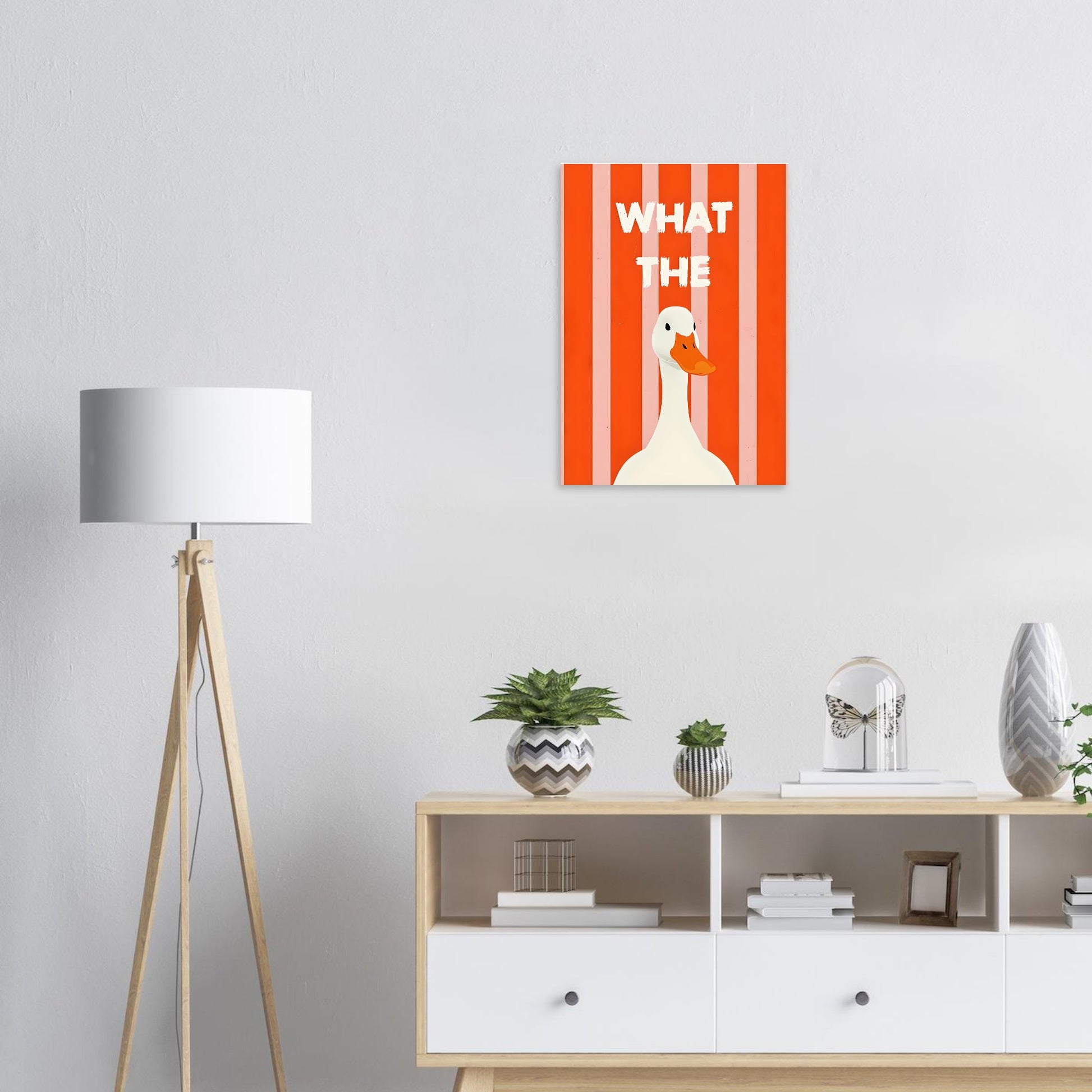Modern interior with a lamp, shelves, and a wall art piece featuring a duck and text.