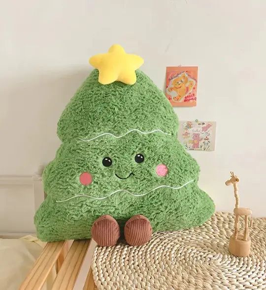 Green plush Christmas tree with a yellow star on top, sitting on a woven surface.
