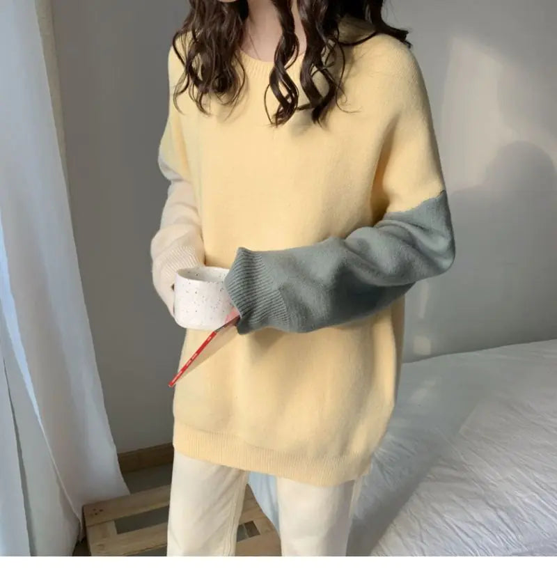 Person wearing a yellow sweater with gray sleeves in a minimal indoor setting