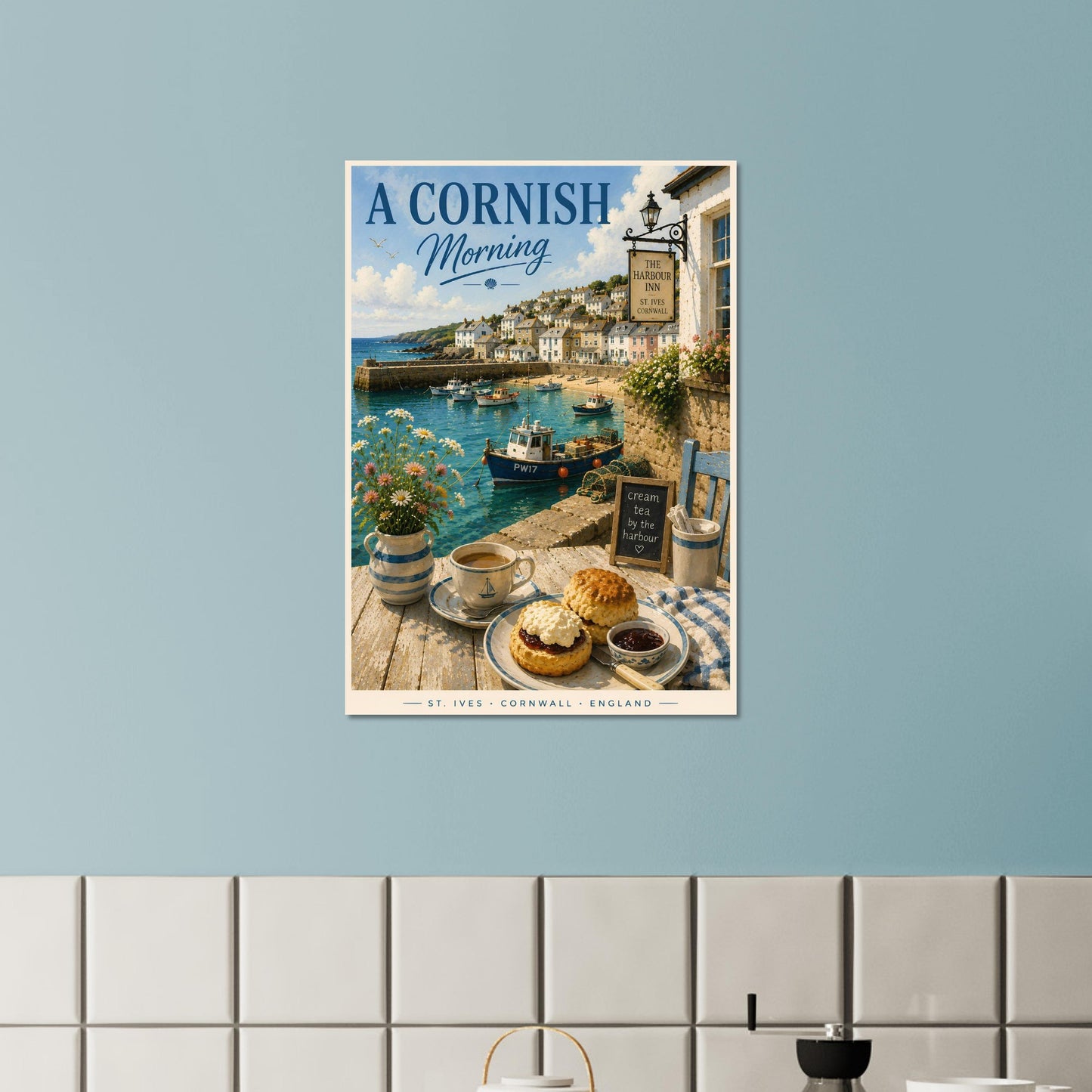 Poster of 'A Cornish Morning' hanging on a light blue wall above a tiled shelf.