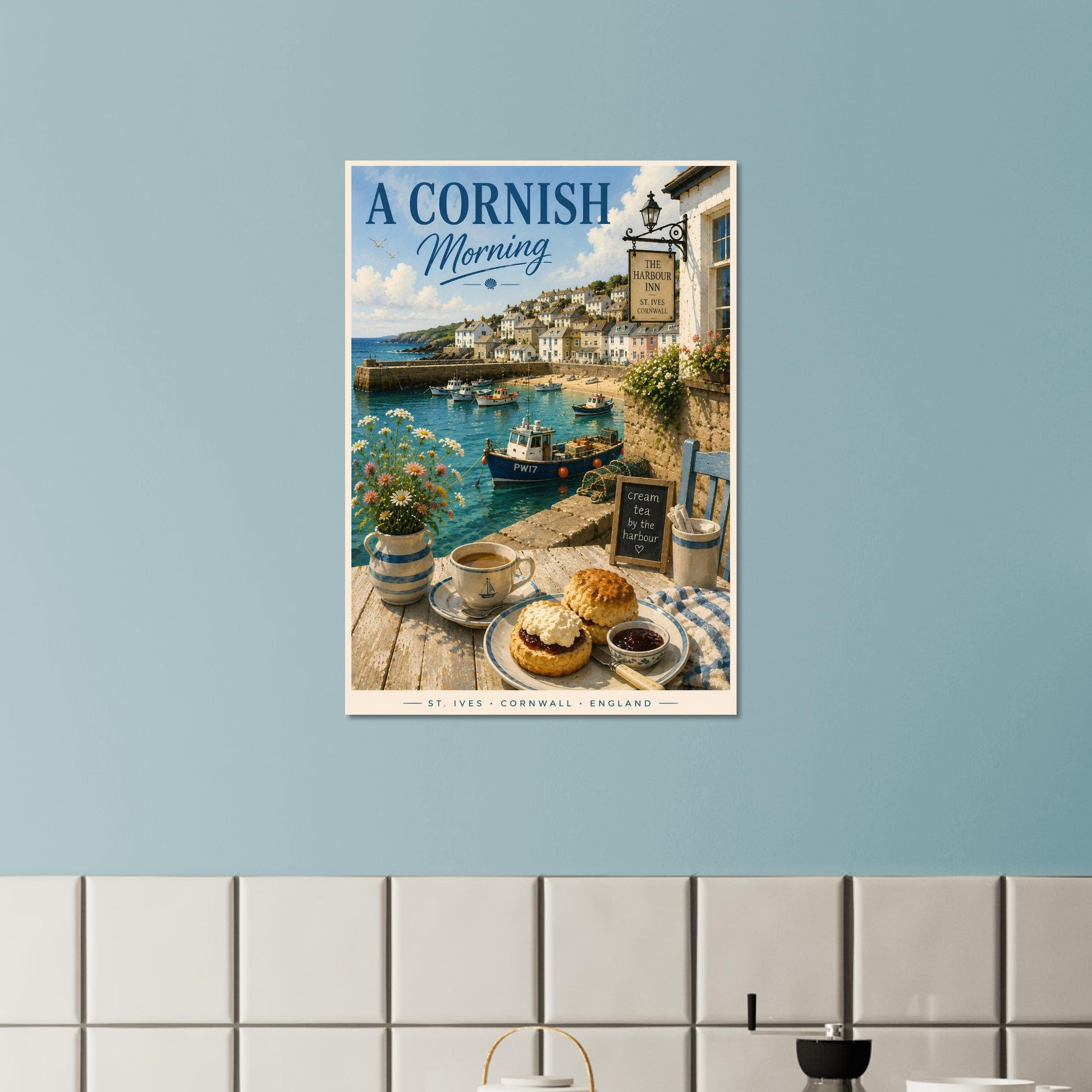 Poster of 'A Cornish Morning' hanging on a light blue wall above a tiled shelf.