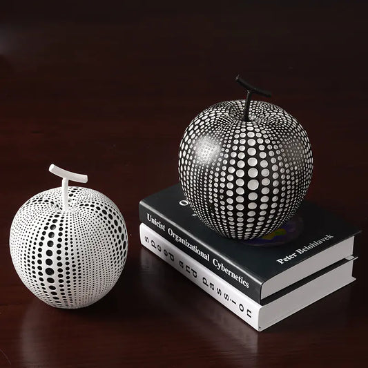 Decorative apple sculptures on books with a dark background