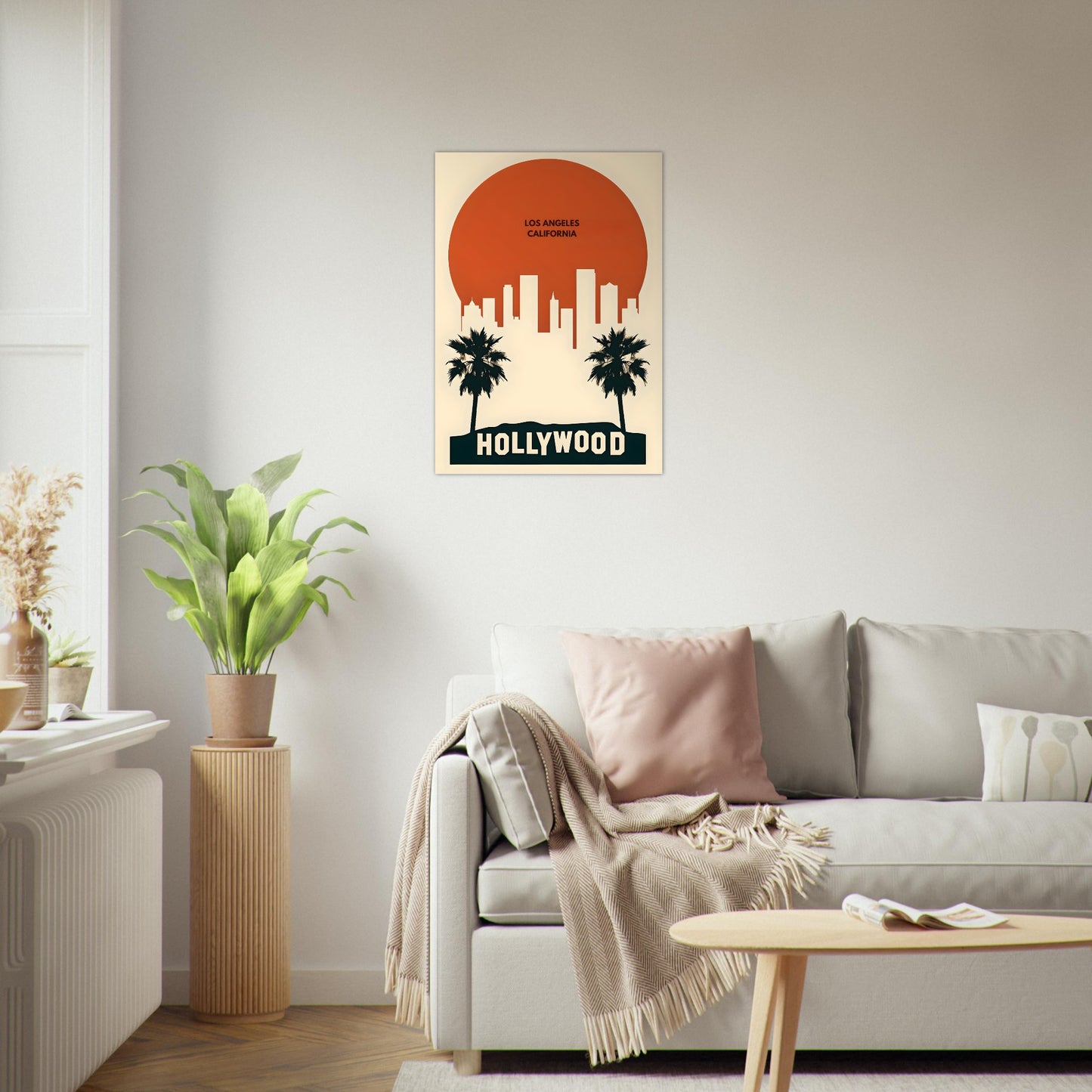 Living room with a 'Hollywood' framed poster on the wall, a sofa with pillows, and a plant.