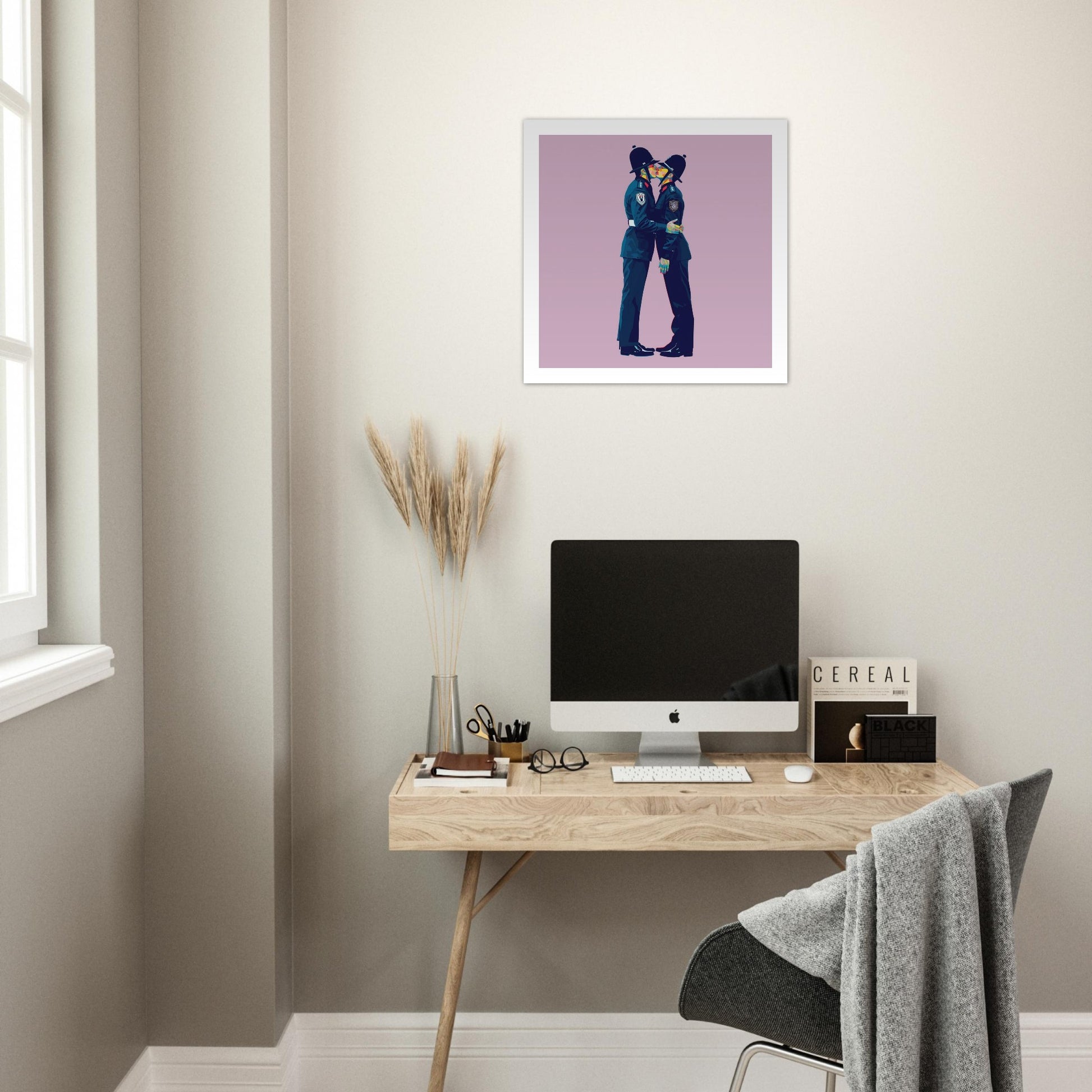 Modern home office with a desk, computer, and framed artwork on the wall.
