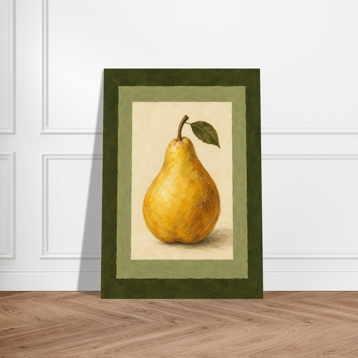 A framed still life art print of a yellow pear with a green leaf, displayed leaning against a white paneled wall on a light wood herringbone floor.