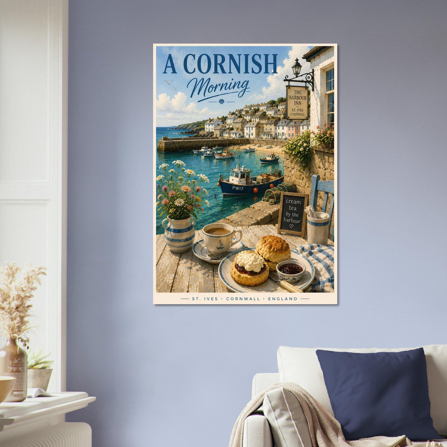 Framed artwork of a Cornish coastal scene with a tea set on a table.