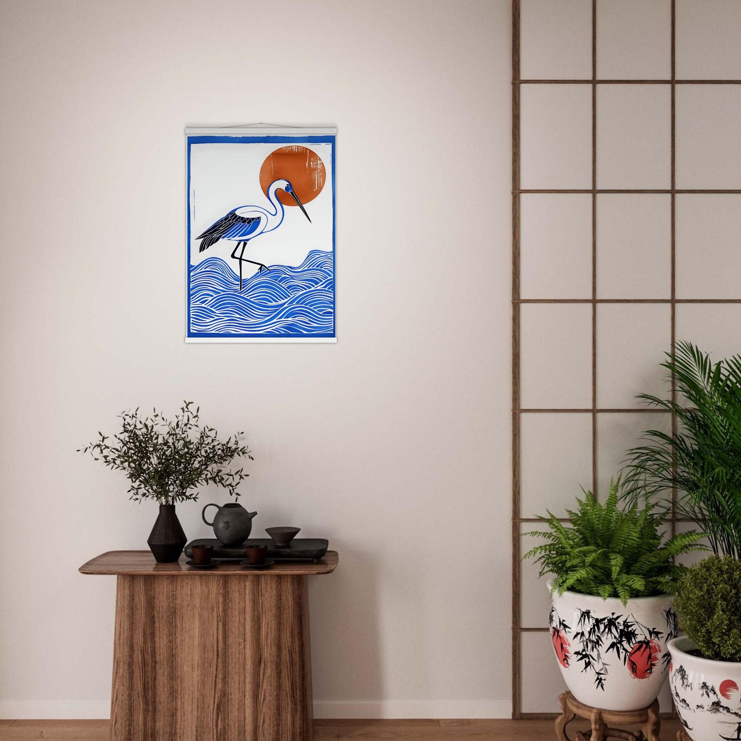 Framed artwork of a crane over water on a wall above a wooden table with plants.