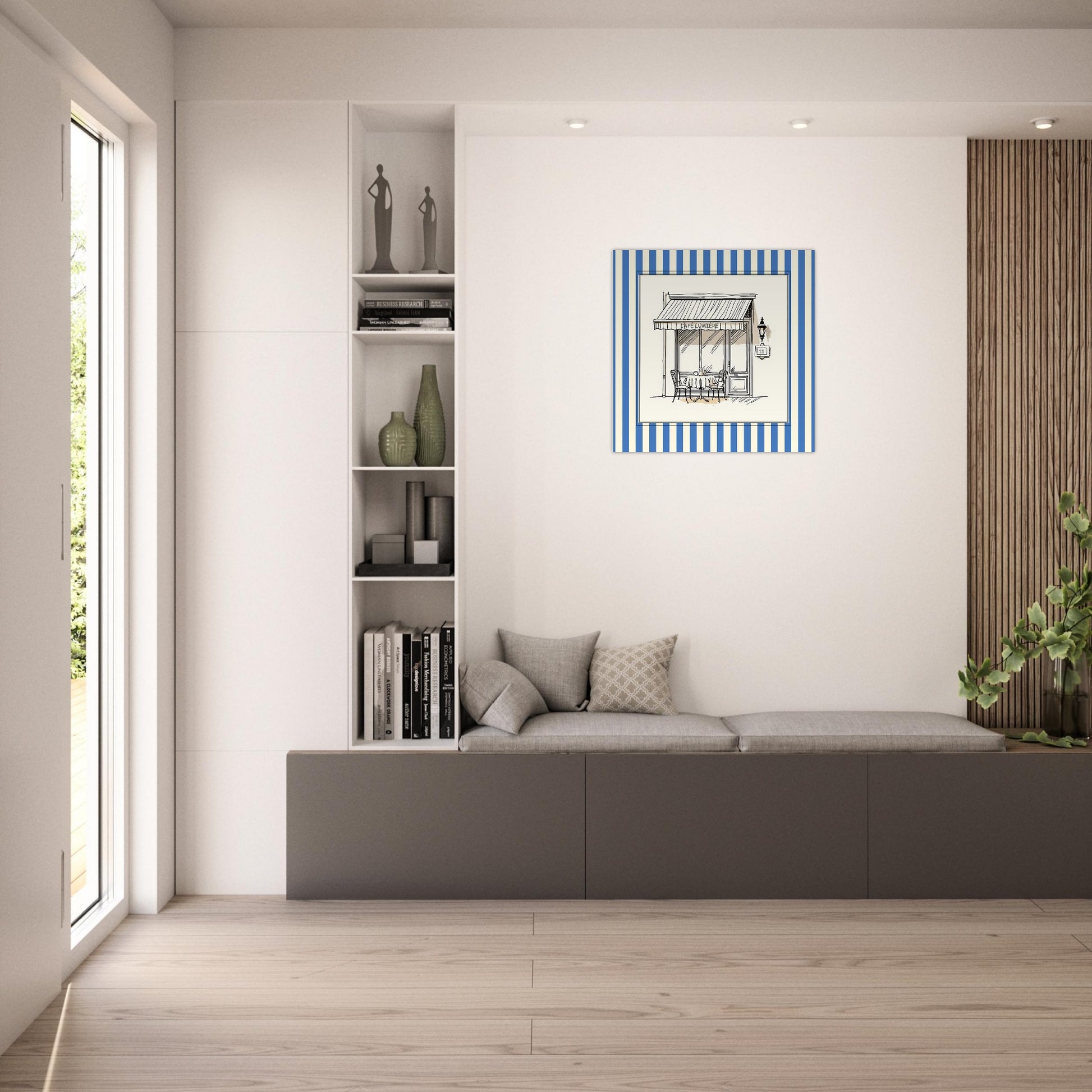 Square blue Paris café art print leaning in minimalist living space above a beige sofa and next to built in shelves