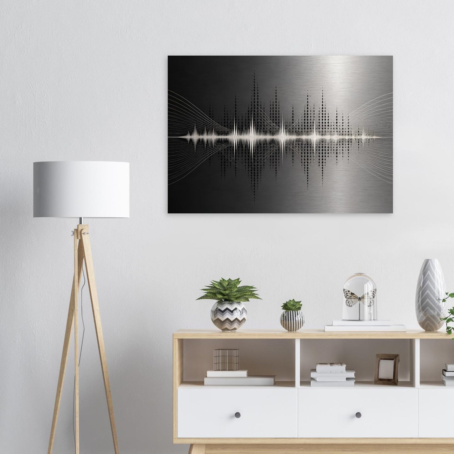 Modern abstract metal wall art displayed above a white console table with lamp, plant and minimalist home accessories.