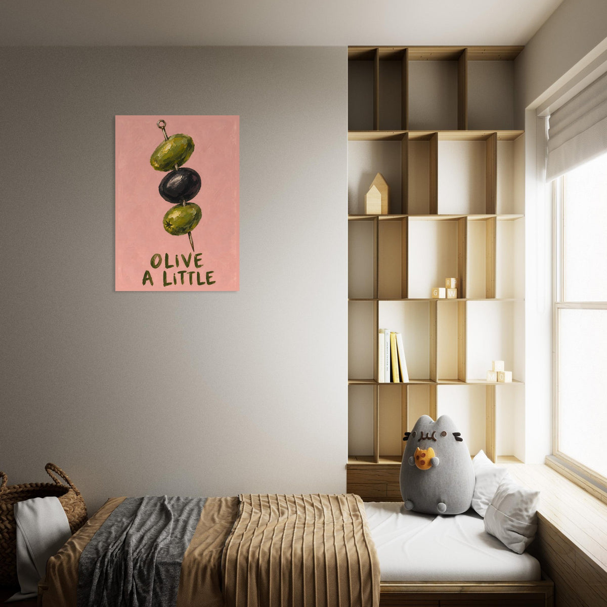 Olive a Little print on a grey wall above a cushioned daybed, beside shelving and a sunlit window.
