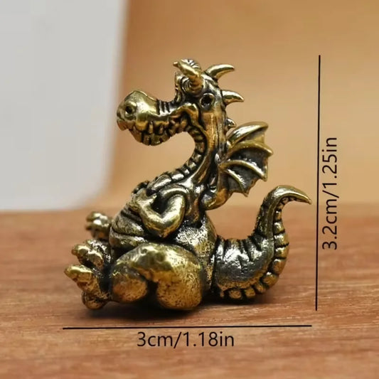 Small bronze dragon figurine with measurements on a wooden surface
