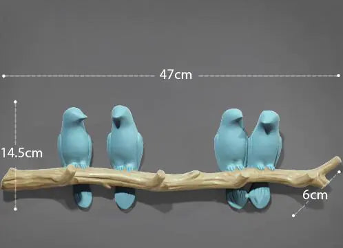 Two sets of blue bird figurines on a branch with measurements indicated.