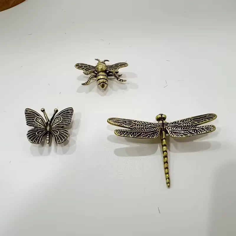 Three decorative pieces shaped like a butterfly, bee, and dragonfly, displayed on a plain white surface.