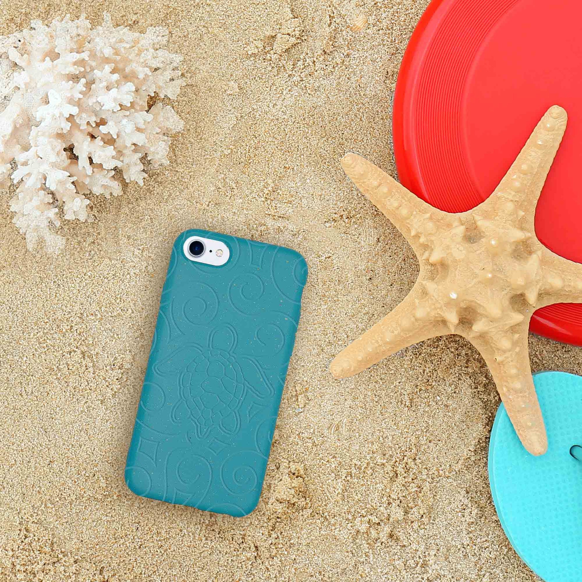 Blue phone case on sand with starfish and red lid