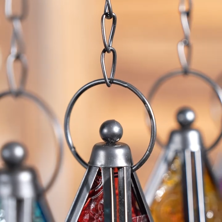 Video of stained glass five-point star candle holders with a black metal frame and hanging chain, designed for decorative home lighting.