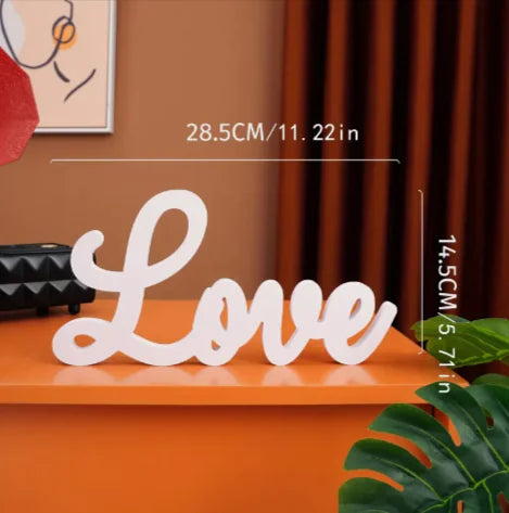 White 'Love' sign on an orange surface with measurements displayed