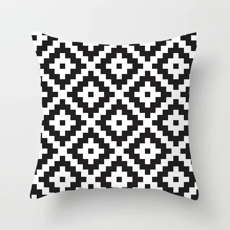 Black and white geometric patterned pillow on a light gray background