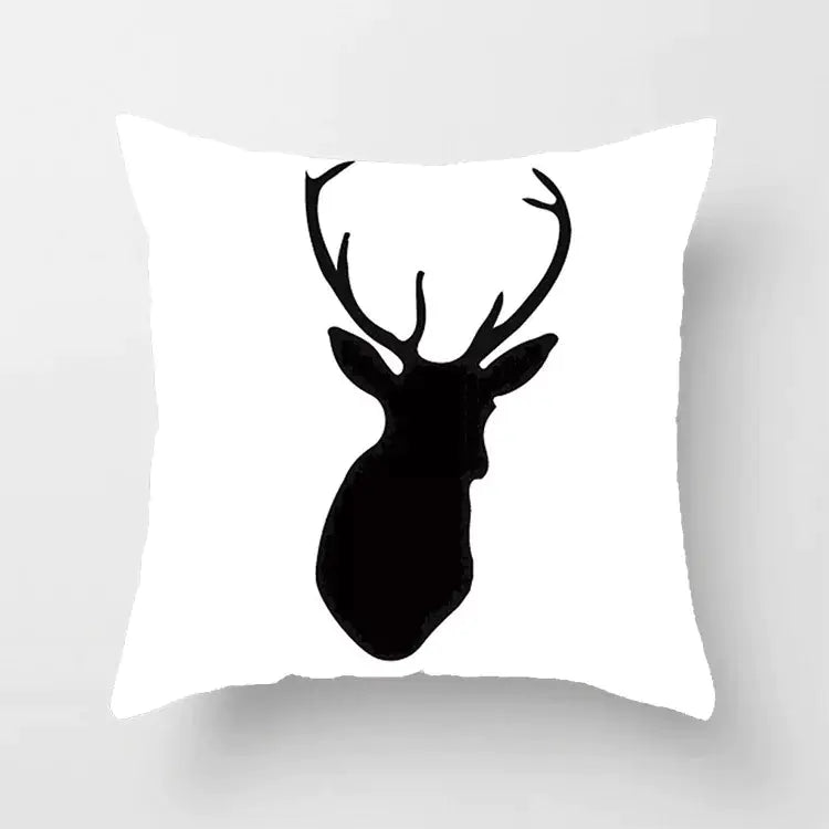 White pillow with black deer head silhouette on a light gray background