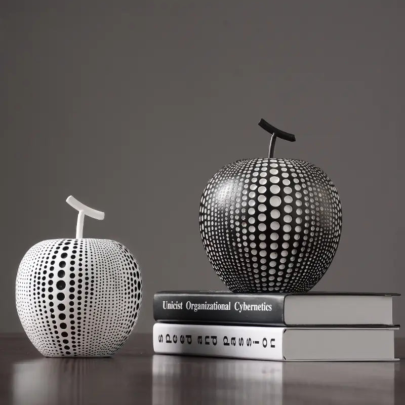 Decorative apple sculptures on books with a dark gray background