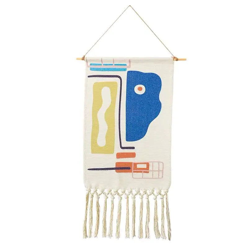 Woven wall hanging with abstract design and fringe on a white background
