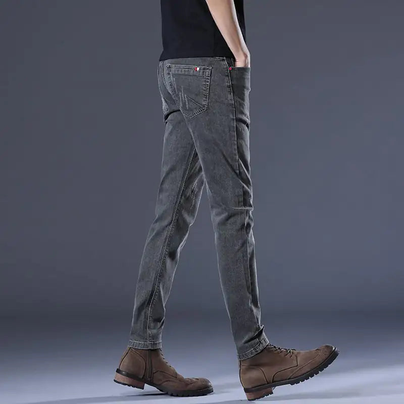 Person wearing gray jeans and brown boots on a dark background
