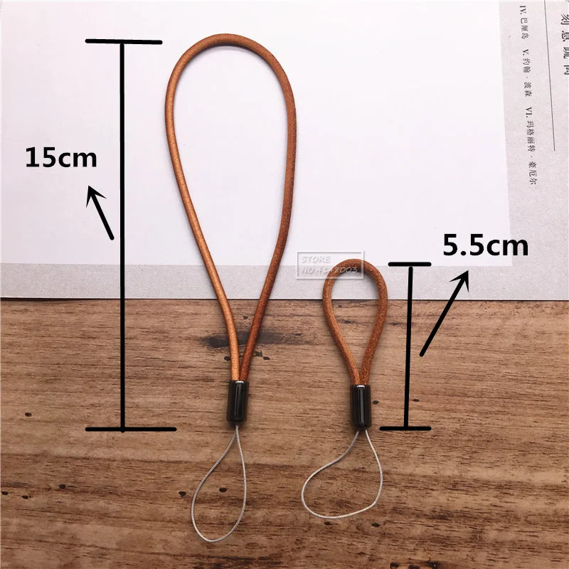 Two leather lanyards with measurements on a wooden surface