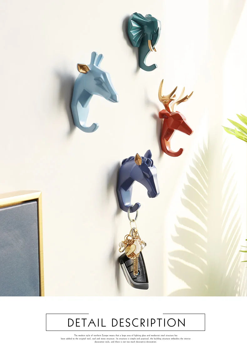 Wall hooks shaped like animals with keys hanging from one of them, on a light background.