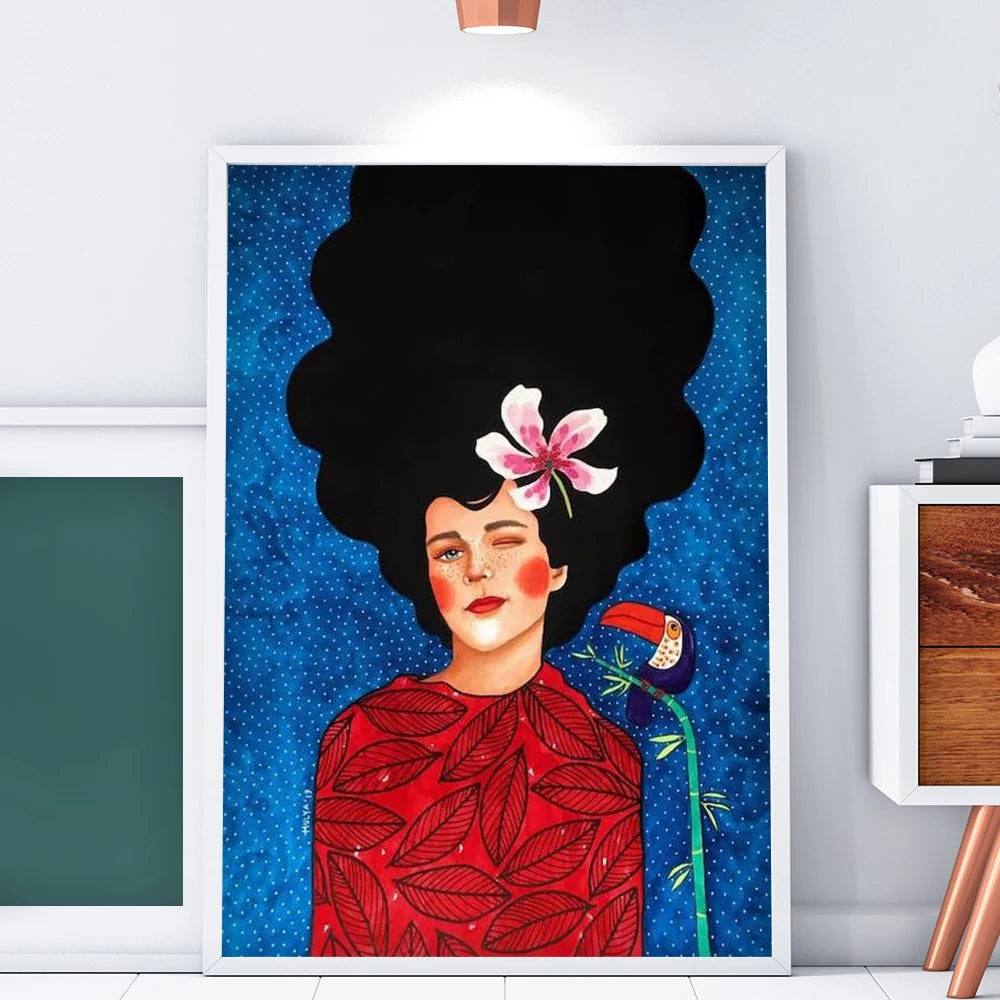 Framed artwork of a woman with a large black afro and a pink flower in her hair, wearing a red dress with leaf patterns, against a blue starry background.