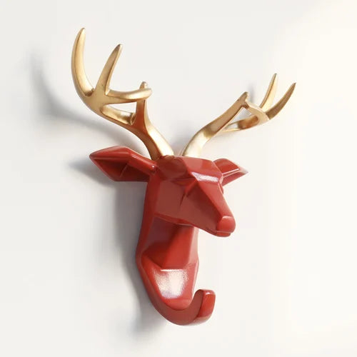 Decorative deer head with gold antlers and red body on a white background
