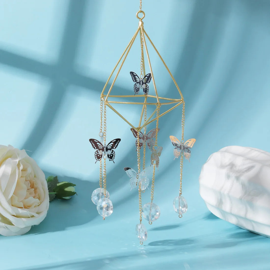 Decorative hanging crystal with butterfly designs on a light blue background
