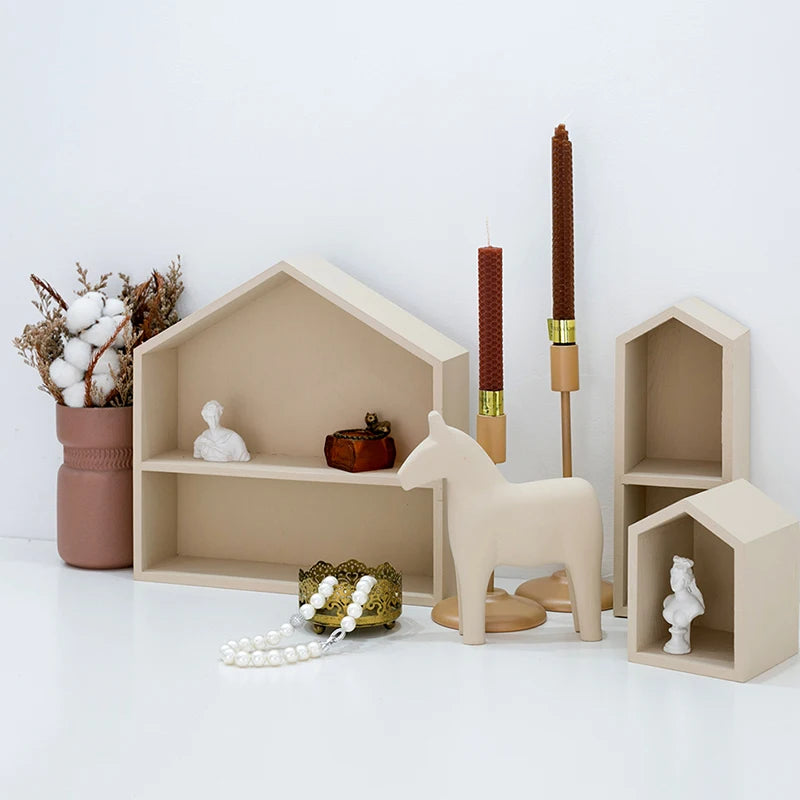 Decorative items including a horse figure, candles, and small shelves on a white surface.