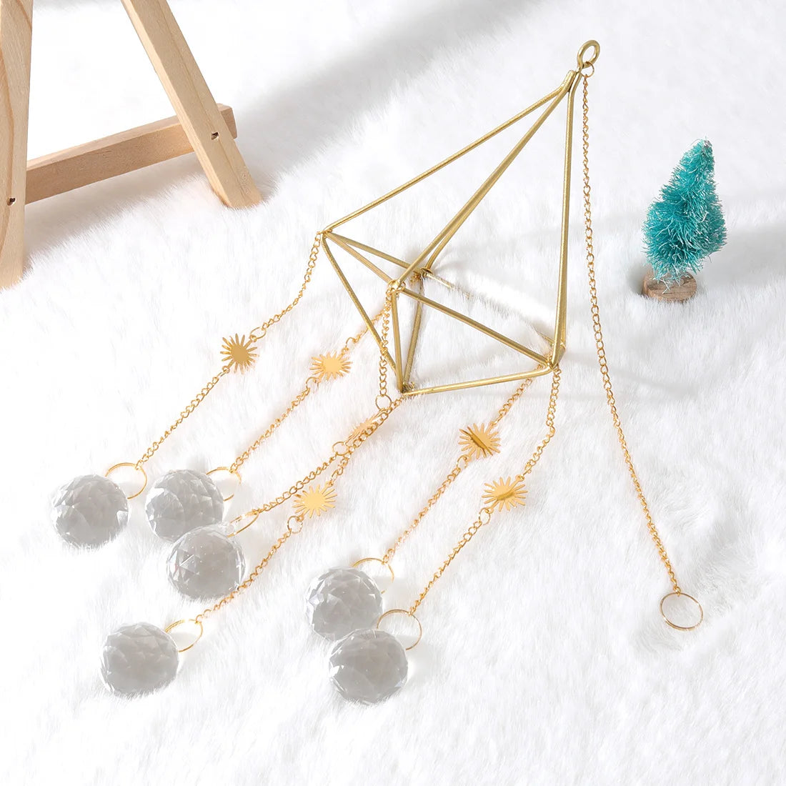 Decorative hanging sculpture with geometric design and spherical elements on a white surface.