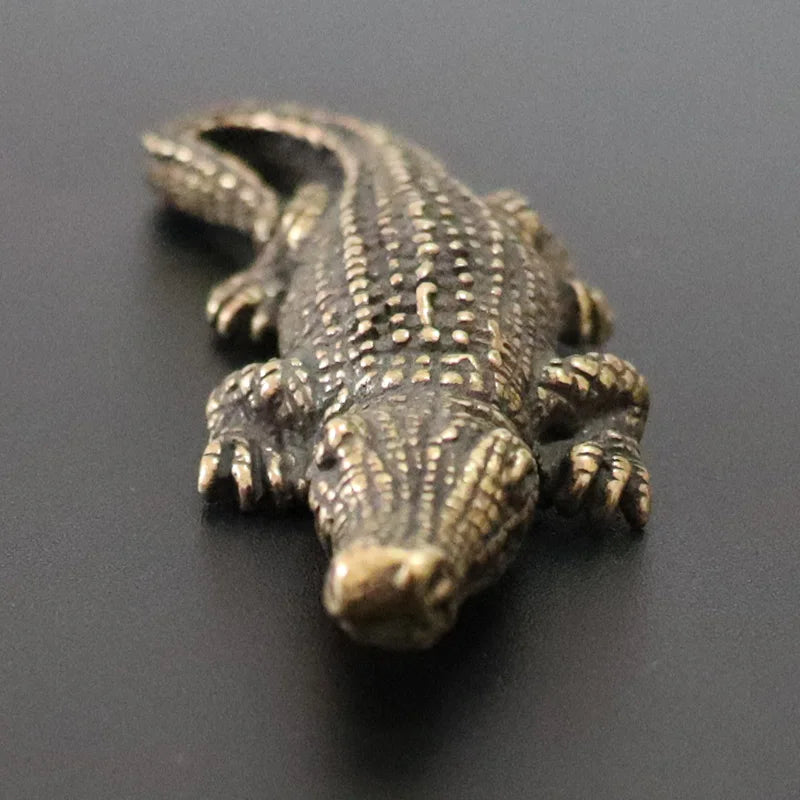 Bronze alligator figurine on a dark background