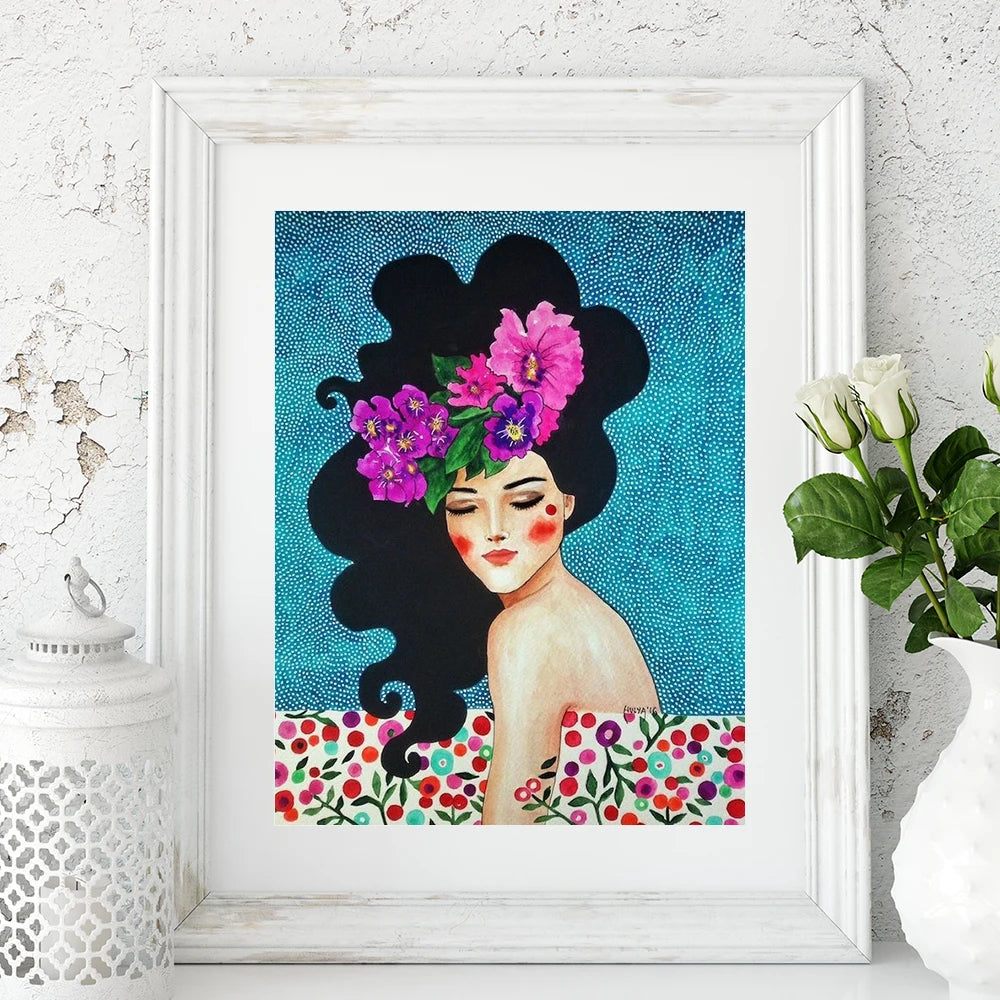 Framed artwork of a woman with flowers in her hair on a blue background